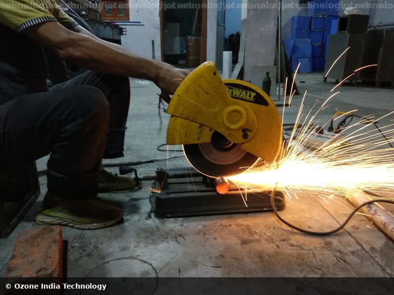 Worker using a DeWalt abrasive cut-off saw, sparks flying